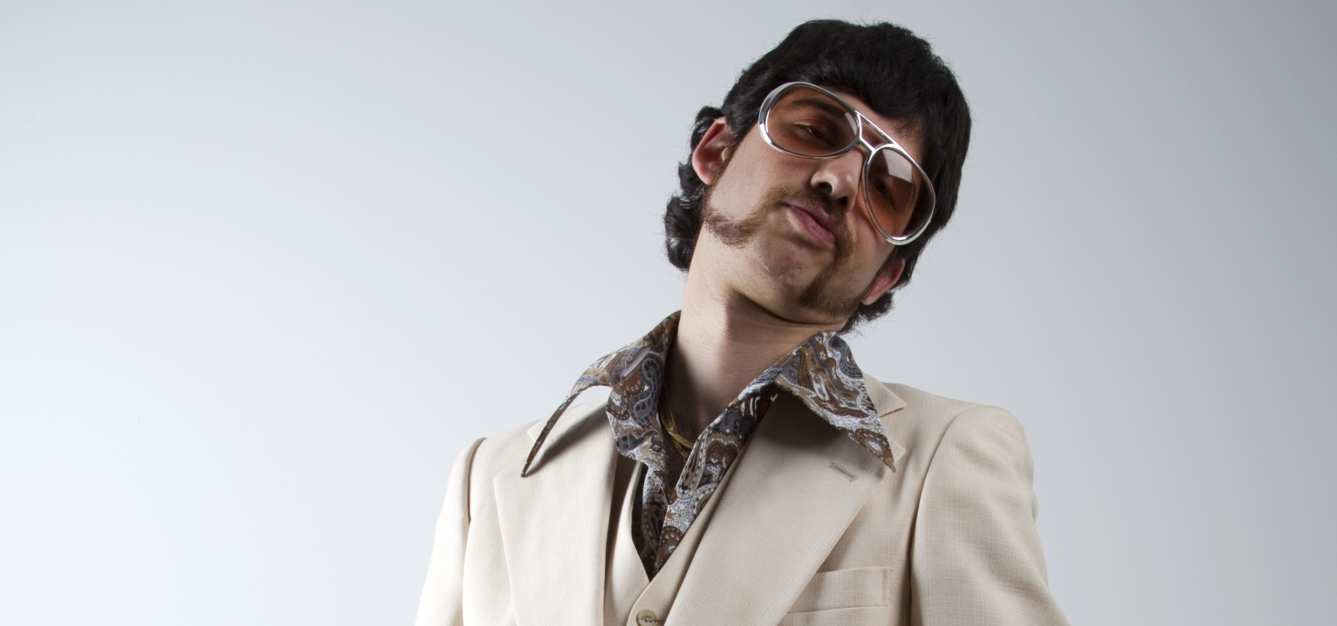 Man with 70's suit, shirt and sunglasses with handlebar mustache