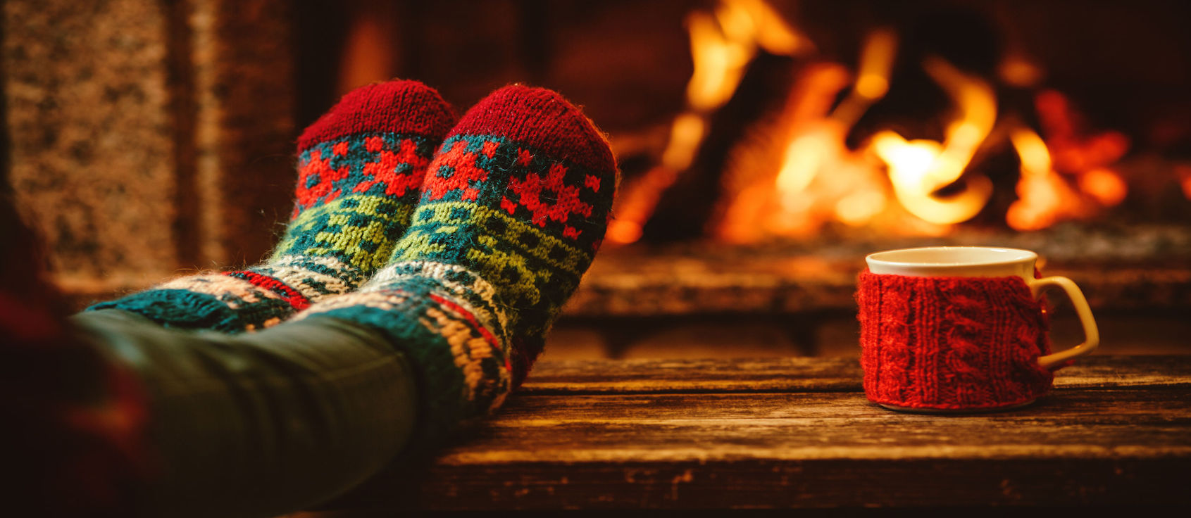 Feet in woollen socks by the fireplace.