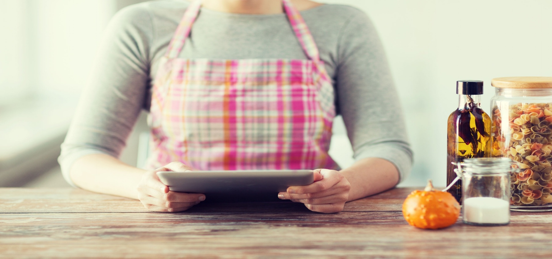 Woman in apron looking at computer tablet