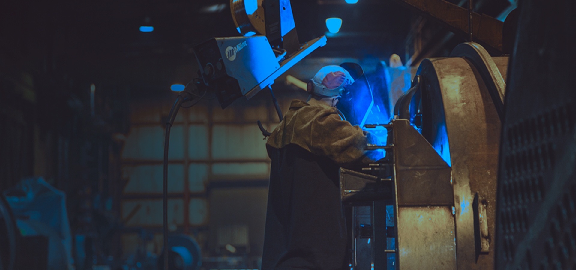 Person welding on manufacturing floor
