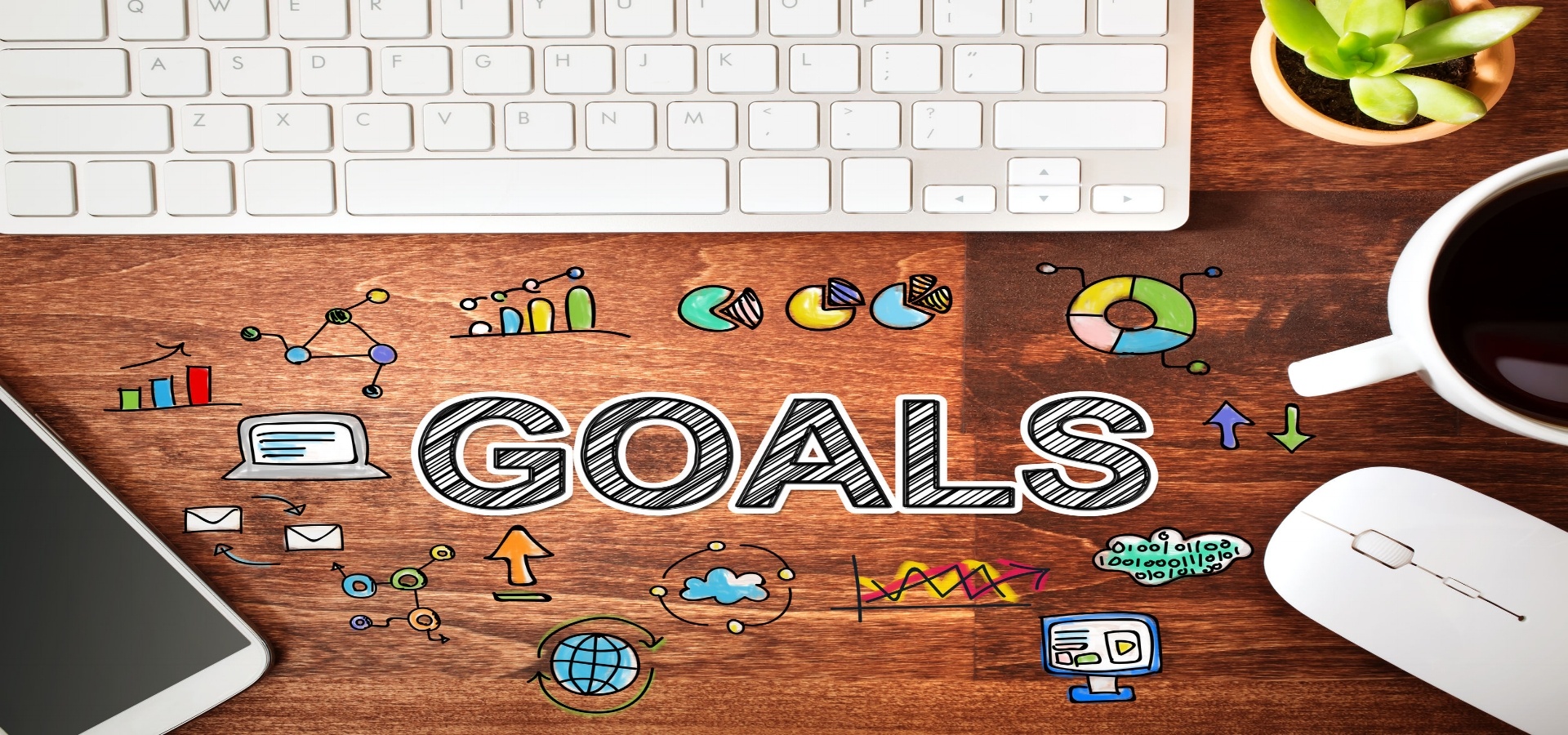 Computer keyboard with the word "Goals" illustrated on a wood table