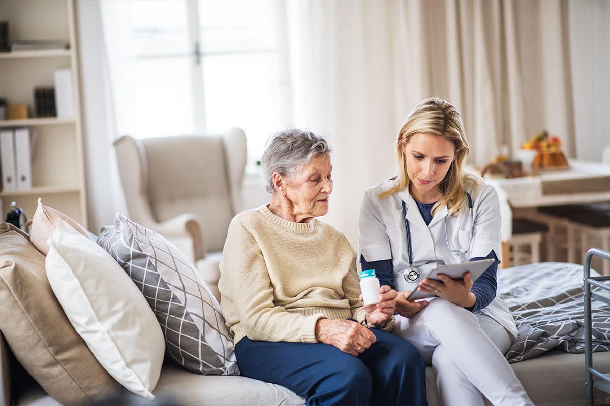 Nurse talking with elderly woman in her home